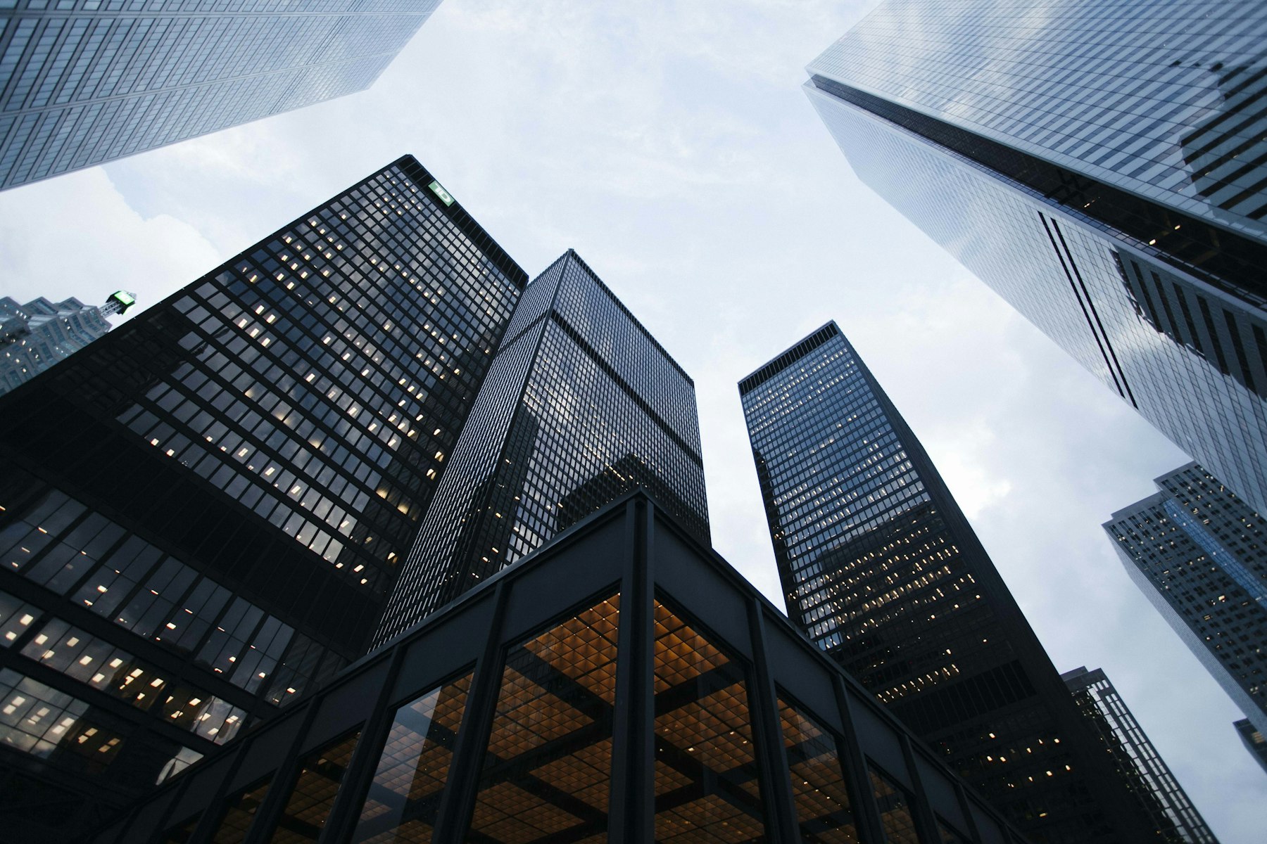 High-rise buildings seen from below, glass façades ordered against the sky (illustrative image)